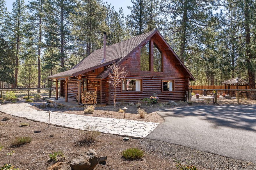 Very private log home bordering both National Forest land and common area! This well-maintained retreat features a vaulted great room with expansive windows, filling the space with natural light. A brand-new Lopi wood stove adds warmth and charm. The main floor includes a primary bedroom with a full bathroom across the hallway and utility room, while two additional bedrooms and a full bath are upstairs. Enjoy the covered front porch, a backyard log gazebo, and a stamped concrete patio. The fully fenced property boasts xeriscape landscaping. The oversized detached two-car garage offers extra storage, with the back and side also fenced—perfect for RV storage with an electric hookup. The gated entry leads to a spacious circular asphalt driveway with ample parking. Here is our FLIP-BOOK for the Hackamore Home: file:///Users/conniemitchell/Downloads/69336%20Hackamore,%20Sisters%20OR%2097759%20(8).pdf