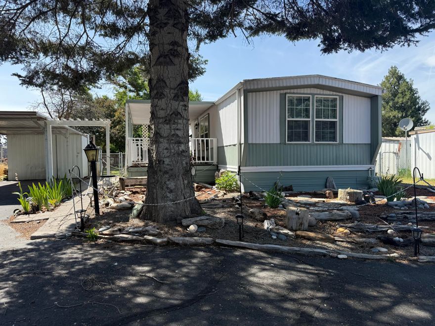 Enjoy the easy living in this 55 & older park, this cozy home is situated at the end of the street on a nice sized lot. The yard is fenced with multiple sheds, carport, garden areas and a covered front porch. Inside the primary bedroom is equipped with its own full bathroom, good sized kitchen and living room, laundry hook-ups and some recent upgrades. The second bedroom and bathroom are spacious and have good closet storage. The monthly rent covers water, sewer, trash. Please submit park approval with any offers.