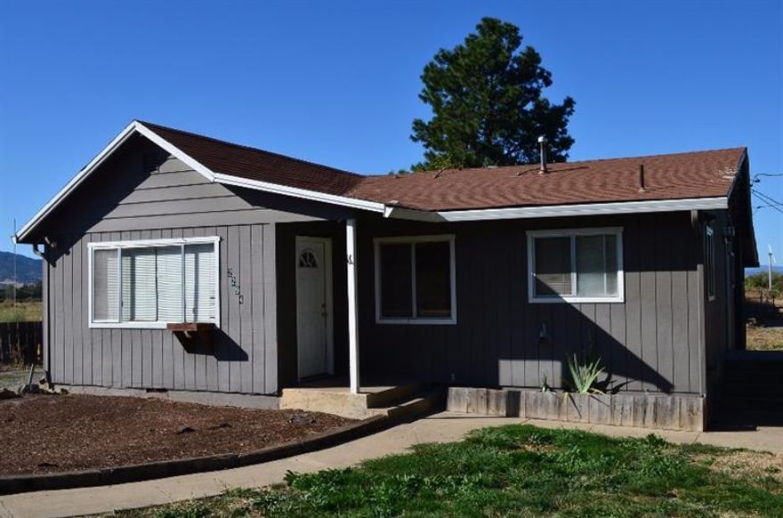 Beautiful level parcel for subdivision with pretty views to the West and the South. New subdivision being built out one property away from this parcel. Currently on well and Rogue Valley Sewer. The older home has 1384 square feet and the Kennel building constructed of cement block has 1194 square feet. Circular Drive, double car garage with large shop building attached to it. Ask the City if the Kennel building can be made into a second home as there is an existing kitchen and bath.