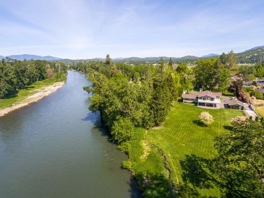 Rolling lawn to River! This classic contemporary home has been beautifully updated. Enter through the gates you are greeted by a park setting. A black topped driveway meanders you to ample parking. Hardwood floor entry leads to the grand living room featuring vaulted open beam ceiling and a cozy fireplace. River views from almost every room! Off the living room is dining and kitchen that face the back yard with views of the river. Some of the features in this kitchen are granite counter tops, hardwood floors, stainless steel appliance. A few steps up takes you to the bedrooms. One guest room has a sun room facing the river. Second guest room has a deck which you can enter into the sunroom. The master on-suite has 2 large closets, large shower and granite counter tops. Outside you will find a covered patio, attached 2 car finished garage plus a detached garage that can be your ultimate shop or rec room. Also, plumbed for a kitchen & has a 3/4 bathroom.