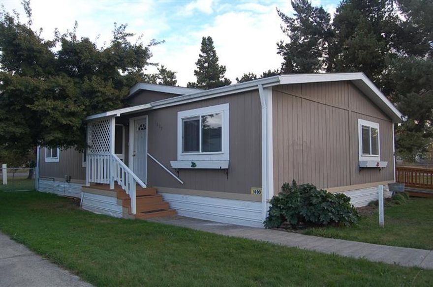 The home is located in manufactured home subdivision, not a 55+ park. Park is on water supplies by a community well and city sewer. Located closed to hospital, shopping, restaurants. Home features 3 bedrooms, 2 baths, and is ready to be moved into. All appliances included, including washer and dryer. Barn style storage building next to the carport. There is a ramp on the back of the home for easy access. The monthly park fee is $415.