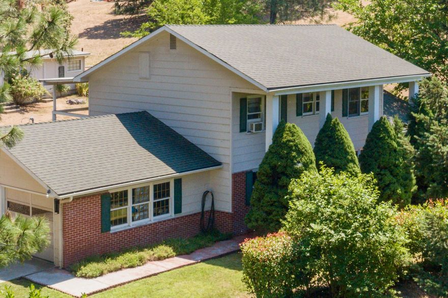 Pass under the 20 Ft columns of this beautiful colonial and escape into the 2.5 acres of this classic farm. A fully fenced oasis with ample water and room for horses the property includes a workshop with 2 entrances, portable garden shed, rustic barn, lovely landscaping with an automatic water system, huge garden with 13 raised beds, 15 established fruit trees, 3 varieties of grapes, and more! Take it all in from the comfort of the double balcony or step inside to find a primary bedroom with an ensuite and jetted tub nicely complimented by two large bedrooms and a 2nd full bath. Downstairs there is a bonus room that can serve as 4th bedroom or an office, an oversized family room with fireplace and living room, plus a kitchen equipped with generous storage.  Located just outside Rogue River and only a 10 minute drive to Grants Pass this hidden gem won't last!