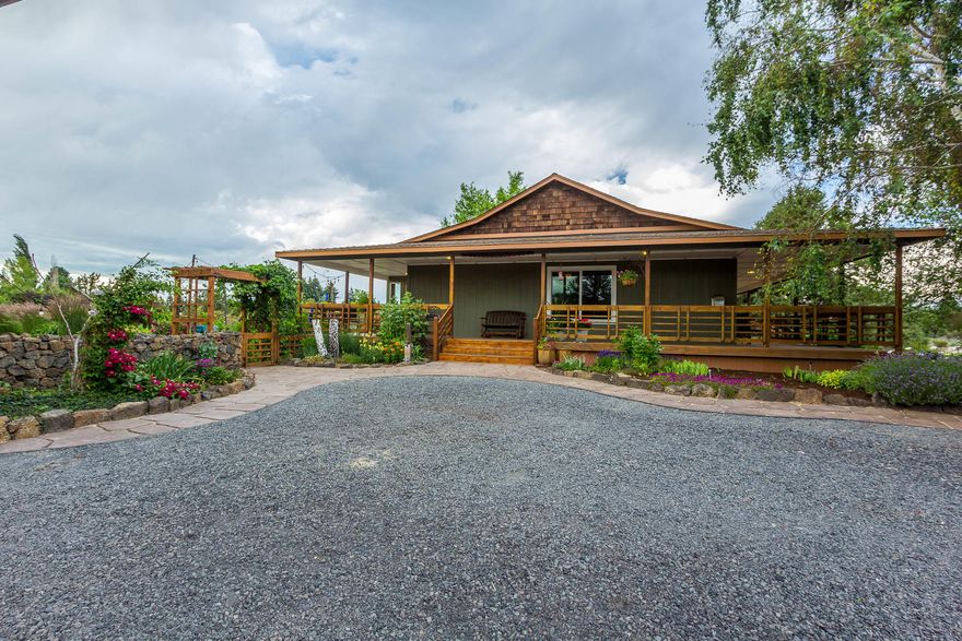 Country quiet, city close!  Serenity awaits on this stunning park-like 2.5 acre setting.   Single level, ranch style home has 4 generous sized bedrooms, 2 full baths.   Wake up to mountain views from the master suite, or step outside the French doors and slip in to the hot tub right off the deck.   Master bathroom recently updated with inviting finishes and radiant heat flooring.  The wrap around porch offers peacefulness and cover in any weather condition.  The pathway(s) surrounding this property are paved with delicately handmade stones.    Enjoy entertaining and watching stunning mountain view sunsets from your extensive backyard patio.  Over-sized garage has room for an RV, heated shop and additional framed out room that could potentially be used as an ADU.   Conveniently, close to nearby Pine Nursery Park, restaurants and shopping!