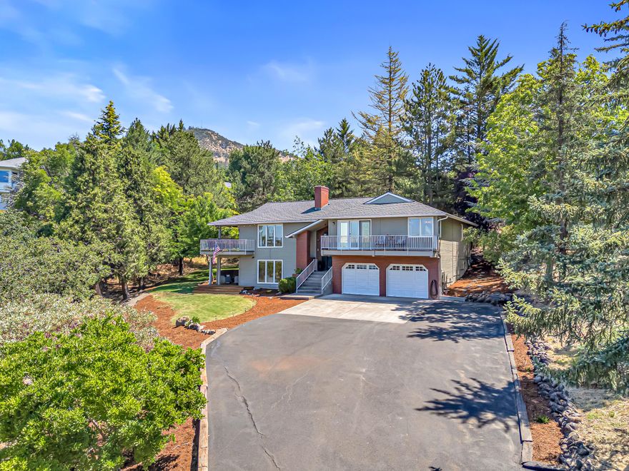 Exceptional East Medford property showcases luxury living on nearly three-quarters of an acre with breathtaking Rogue Valley vistas. The completely remodeled 5-bedroom home features a stunning great room with vaulted ceilings, built-in fireplace, and floor-to-ceiling windows that frame spectacular views. The spectacular kitchen boasts quartz countertops, walk in pantry, stainless appliances, and farmhouse sink. The master suite offers a private deck and spa-like bathroom with soaking tub, tile shower and dual vanities. The lower level provides flexible living with separate entry, two bedrooms, office, full bath with sauna, and great room with floor-to-ceiling windows - ideal for multi-generational living. Three expansive decks provide multiple outdoor entertaining spaces, while the private yard features playground, fire pit, and adventurous zip line, all bordered by a seasonal creek.  Plenty of room for your toys with a large 2 car garage with workshop and storage. Amazing Home!