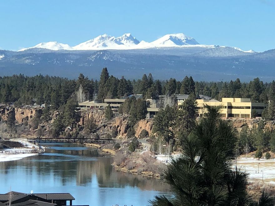 Discover the allure of this captivating townhome nestled on the Bluffs at River Bend in the heart of the Old Mill District. Enjoy picturesque vistas of the Deschutes River, Cascade Mountains, and the charming Old Mill District itself. This residence boasts a spacious entry, offering 3+ bedrooms and 3 baths, with a versatile office/4th bedroom and a full bath on the main level. Immerse yourself in the beauty of the island kitchen featuring slab countertops, a convenient walk-in pantry, and a floor-to-ceiling rock fireplace in the expansive great room. The master suite beckons with a second view balcony, a separate shower, and a luxurious jetted soaking tub Amenities include a large double garage, a separate utility room, and the comfort of central air. Embrace the lifestyle that comes with this exquisite townhome, where every detail reflects a perfect blend of elegance and functionality.