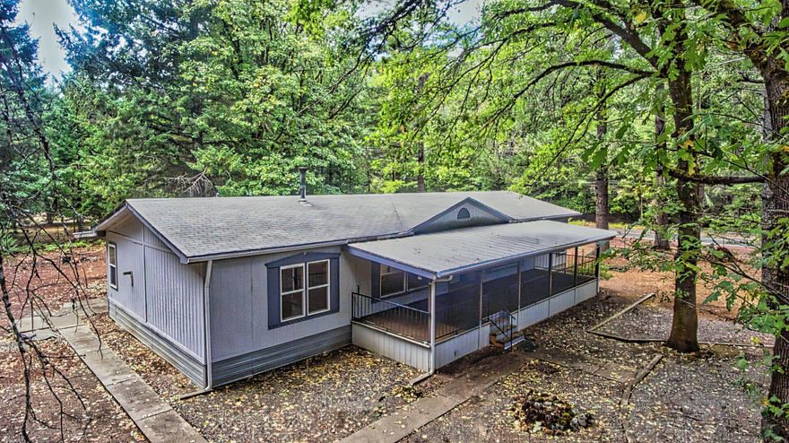 Here's your private home among the trees.
Well maintained 1,809 sq ft 3 bed 2 bath manufactured home on 2.5 fenced acres.
Beautiful tall trees dot the home's surroundings and a manicured forest fills the rest of the acreage.
Here there's a detached 2 car garage, covered front porch and an enclosed back porch.
Skylights in the kitchen and guest bathroom provide a bright atmosphere.  The primary bathroom was recently updated.  It has a separate tub and shower setup and double vanity.
Attention culinary enthusiasts!
This kitchen has plenty of space, a kitchen island, all the cabinets you could want.  There are recently updated appliances with a modern electric cooktop, range hood, garbage disposal.
This home is tucked away from it all in the Ken Rose neighborhood but less than 10 minutes from Cave Junction and 40 minutes to Grants Pass.
Call to schedule your showing today!