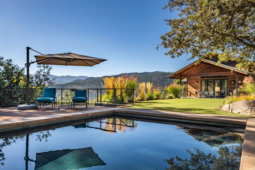 One-of-a-kind secluded family compound with resort-quality construction, thoughtfully designed by an award-winning local architect. The fully-surveyed 100+ acre property features three separate finished living areas including a three-level main home, guest cottage, and detached office suites — all with fire-resistant reclaimed old-growth redwood siding and metal roofing. Unparalleled panoramic views of surrounding peaks and undeveloped government land from four unique redwood decks. High-end finishes throughout must be experienced in person! The grounds include a gorgeous heated Pebble Tec pool with remote-controlled safety cover, extensive dry-stack artisan rock terracing, circulating pond with waterfall, raised garden beds, fruit trees, and lavender fields. Outbuildings include a detached garage shop, tool shed, well house, as well as an additional 20x24 building pad approved for a 2-story structure. Inquire for details!