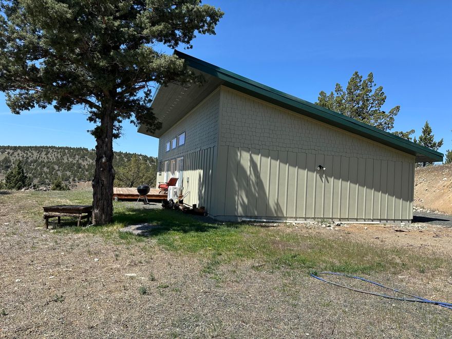 Price Reduced - Passive Solar Home on 1.34 Acres: Easy to Heat and Cool. This beautiful two-bedroom, two-bathroom home boasts stunning mountain views, thanks to its abundance of windows and a spacious deck designed for enjoying the scenery. Offering 1,200 sq. ft. of comfortable living space, this home is heated by a wood stove and a mini-split system, ensuring warmth in the winter and coolness in the summer. Quality Construction: Built with upgraded materials, it features R-38 compact insulation in the ceilings, Wirsbo plumbing, plywood sheeting, a durable metal roof, and hardi-plank siding. Garage and Layout: An attached 450 sq. ft. single-car open unfinished garage. The open concept design features vaulted ceilings and wooden beams, barn doors with kitchen appliances and a washer and dryer also included. Outdoor Potential: The exterior presents an open canvas, allowing you to finish it to your liking.