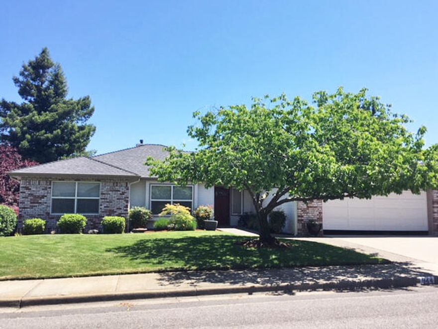 Spacious 2034 sq. ft. 3 bed/2 bath single level home on one of the nicest streets in Oak Knoll Meadows. Quiet location close to golf course. Very well-maintained home by one owner since built. New 40 yr. roof 2019 & interior paint just completed. Move in ready! Great curb appeal. Spacious entry area opens to large vaulted ceiling living room with gas fireplace and a wall of windows. Living room is open to a formal dining or flex room. Large peninsula kitchen with nice wood cabinets and expansive storage including a large pantry cupboard. Hardwood flooring plus newer carpet and timeless white tile countertops thru-out. Large primary bedroom suite with bay window and three closets. Third bedroom by front door with double doors & window seat would make a great office too. Neutral tile floors & showers in both bathrooms. The covered deck is accessible from the living room & the dining/flex room and is a lovely place to enjoy the treed view of the neighborhood & peek mountain view.