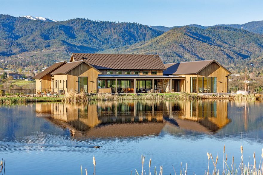 Stunning mountain modern home with panoramic views of the Siskiyous and surrounding Rogue Valley. Located in the beautiful hamlet of Ashland with world-class theater, dining, fly-fishing, skiing, and just 20 minutes to Medford Intl Airport, this home will satisfy the most discerning buyer. Completed in 2023 by Asher Homes, the open floor plan is an entertainer's dream. The kitchen island is a wonderful gathering place, and the Wolf and Sub-Zero appliances are chef's quality. The great room opens to a covered patio with a gas-fire table and an outdoor kitchen overlooking the pond. A private deck with a hot tub and outdoor shower are accessed from the spacious primary suite. Downstairs is over 1000 ft of finished basement with a full bath and plumbed for a kitchenette. Perfect for an in-law unit, workout space, home office or art studio. The irrigated property has a riding ring and space for grazing while leaving plenty of room for new ideas and projects.  Live your Ashland dream.