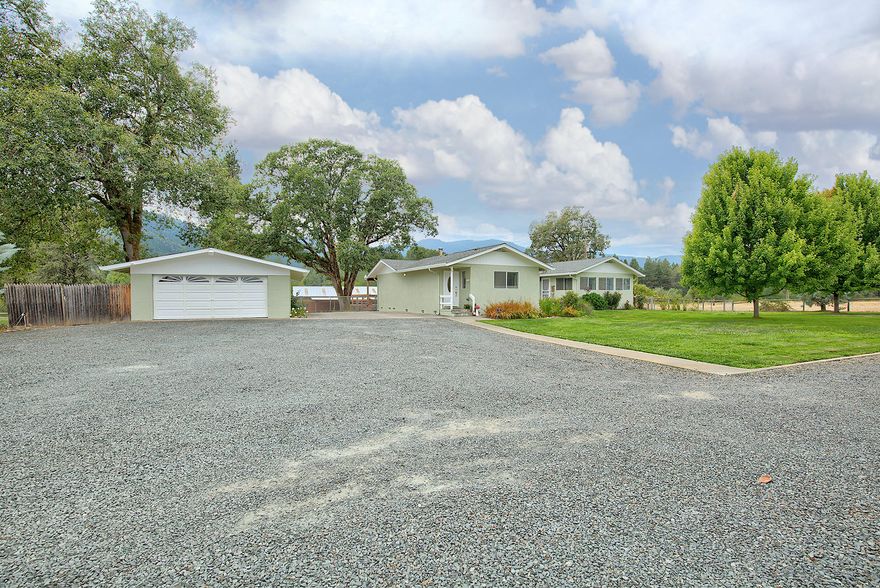 Gorgeous gated 8.4 acre horse property with the most amazing panoramic views of this valley!! Located on Evans Creek, this property has so much to offer. The spacious and comfortable home has nearly 2000 sq. ft. and was updated in 2002. It features a grand living room with lots of windows, a huge den, open kitchen and dining room, master suite and 2nd bedroom and bath. Outside there are two detached 2 car garages ~ one is currently a shop. There's a beautiful 5 stall barn with small arena, tack room and huge overhang for equipment. It also has a very large hay barn and is fenced and cross fenced. Plus, irrigation rights from Evans Creek and a great well. This property is tucked back off the road and has a very desirable, private setting. This is a rare find ~ call for an appointment today!!