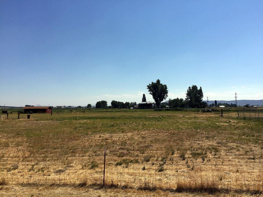 This 1.15 Acre is only a mile away from all the Henley schools. The property has a recent septic inspection and is approved for a special system. This property had irrigation rights, gas at the street and is completely fenced. Area has other small acreage homes with rural lifestyle but not far from schools and shopping. This is a place where you can build that special little farm house with room for animals and gardens.