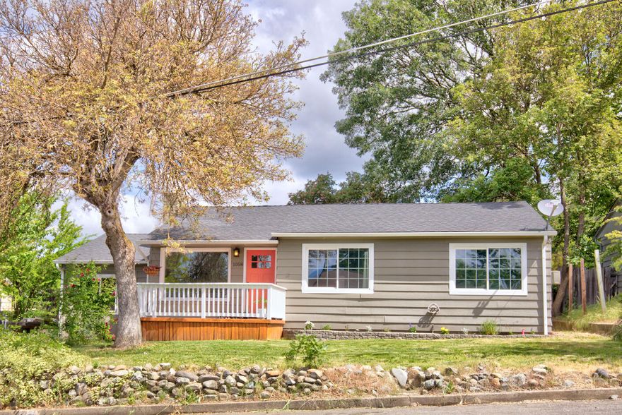 Desirably located, this Home has all the character and curb appeal you've been wanting! Built in 1951, the 3 bed, 2 bath home has 1,750 sq. ft and features two gathering spaces. Living room is light & bright with fresh interior paint, laminate flooring, a gorgeous fireplace and picture window. Updated kitchen has corian countertops, tile floors, dining area and additional living space with french doors out to the deck. Primary bedroom features an updated bathroom and slider out to its own private deck. Laundry room has corian counter, sink and washer/dryer already in place for you. This spacious, fully fenced .23 acre lot gives you plenty of room to enjoy outdoor living. Play area, garden, entertaining, it can all happen here! Home is situated within walking distance of Lincoln Elementary and Grants Pass High School, as well as shopping and city services. Make your appointment to see this Beautiful home today!