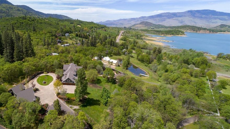 One of a kind Ashland Estate with 9000+ sq ft of luxurious space. Versatile floorplan featuring 6 bedrooms & 5 baths in the primary residence + 1000 SF guest house. Primary master suite features sitting area, fireplace, jetted tub & incredible walk-in. Impressive entry with grand staircase and great natural light. Formal living room has cathedral ceilings, floor to ceiling rock fireplace & lots of windows. The informal living area has numerous built-ins, fireplace & French doors out to large wrap around porch. Gourmet kitchen. Informal & informal dining rooms. Four addtn'l bedrooms upstairs with Jack & Jill'' bathrooms between. Huge rec room and sun porch. Secondary master suite on the main level with private bath. Just over 5 acres with views of Emigrant Lake. Gated and tree line drive. Expansive decks and patios, mature landscaping, lagoon pool with a swim-up bar, hot tub, outdoor kitchen & a pool house with a full bath. 3 garages with parking for 9 cars. A true Estate.