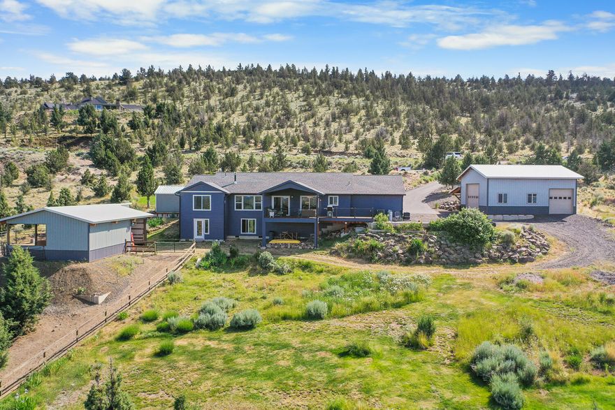 This beautifully maintained & thoughtfully designed property offers a perfect blend of comfort, quality, & functionality. Enjoy stunning views from the covered deck & home, which is filled w/natural light. The great room features a unique propane fireplace, while the kitchen boasts quartz counters, a large island w/storage, insta hot tap, & recirculating hot water. Additional upgrades include a whole house water filtration system, heated tile floors in the primary bath, bamboo flooring with 3/8'' subfloor, & solid interior doors. Outside, you'll find a 28x36 shop w /loft, 220, drains, & full RV hookup, plus a 2-stall barn w/hay storage, fenced paddock & riding area. The beautifully landscaped yard features a deep koi pond w/waterfall, greenhouse w/water lines, fenced garden, 7 frost-frees, &  powered garden shed. Paved drive & 400-amp service complete this exceptional property.  Additional neighboring 2 acre lot is available and buildable.  Furnishings are available w/exceptions for $