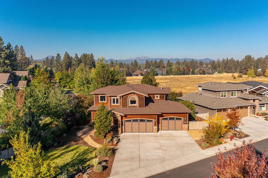 PRIME location in SW Bend's River Rim! Situated on a private .27/AC corner lot and backing to River Rim's coveted Elk Meadow, this Northwest design features Cascade Mountain views and quality craftsmanship throughout. Great Rm concept w/vaulted ceilings, exposed beams, and stone surround fireplace, opens to an additional light-filled living rm creating an ideal space for entertaining. Chef's kitchen offers warm wood accents, informal dining bar and walk-in pantry. Dining area w/outdoor access overlooks the peaceful meadow setting and Cascades. Spacious Main Level Primary Suite w/2 walk-in closets, dual vanity, tiled shower and jetted soaking tub. Additional BR on main level. Upstairs:3rd BR, full BA and Bonus Rm/4th BR. Charming backyard w/tranquil water feature and multiple paver patios designed to take in the views year-round. Oversized 3 car garage w/shop area. Moments to Wildflower Park, schools, the Deschutes River and just 2 blocks to neighborhood shopping, cafes and restaurants.
