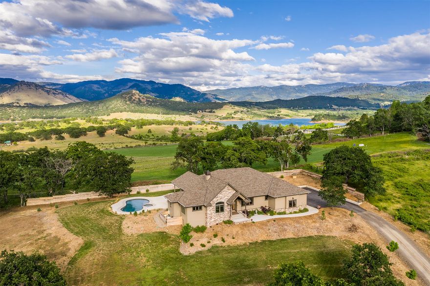 Thoughtfully designed custom home in the most private setting w/ views of Emigrant Lake. With 4 bedrooms + a bonus room, 3 full baths & 3,700+ SF, the floorplan is versatile, yet inviting. Stunning granite island centers the gourmet kitchen; complete with top of the line stainless appliances. Impressive great room is vaulted, features a wall of windows, sweeping views & boasts an incredible floor to ceiling fireplace w/ stone surround & historic, reclaimed mantle. Owner's Suite has dual closets, tiled bath w/ heated floors nice separation from the other rooms. Incredible utility rm w/ built-ins. Rich bamboo flooring, custom cabinetry, wood windows & doors, central vac, Geothermal heat & more! Heated saltwater pool w/hot tub, usable and irrigated land with creek frontage. Detached shop has 1100+ SF of enclosed RV parking, hookups and a 1200 SF+ guest apartment w/ full bathroom. 7 stall barn w/ bath & hay storage & tack room. Highspeed internet, great producing well and gated entry.