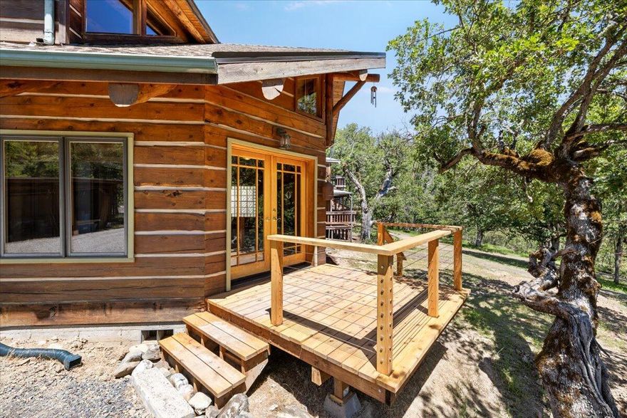 Soaring vaulted ceilings and floor-to-ceiling windows create a dramatic entrance to this custom lodge-style home. Crafted from 10# Eastern Oregon lodgepole pines, the unique ''ship's prow'' design floods the living space with light and frames serene mountain views. The open kitchen with breakfast bar adjoins a dining area and den, where a built-in wood stove adds charm and welcoming warmth. Enjoy radiant heated tile, a luxurious steam shower, and clawfoot tub in the primary suite. Premium finishes include refinished pine floors, wool carpet, and built-in sound system with 18 speakers. Rooftop hot water with recirculating pump, two certified wood stoves and heat pump ensure comfort and efficiency. Outdoors, unwind on the cedar deck or in the above ground pool surrounded by trees. A detached two-story workshop and non-residential cottage complete the package.  Modern systems and timeless craftsmanship make this home a rare retreat. New roof in 2023, 2.25% VA loan assumable by veteran.