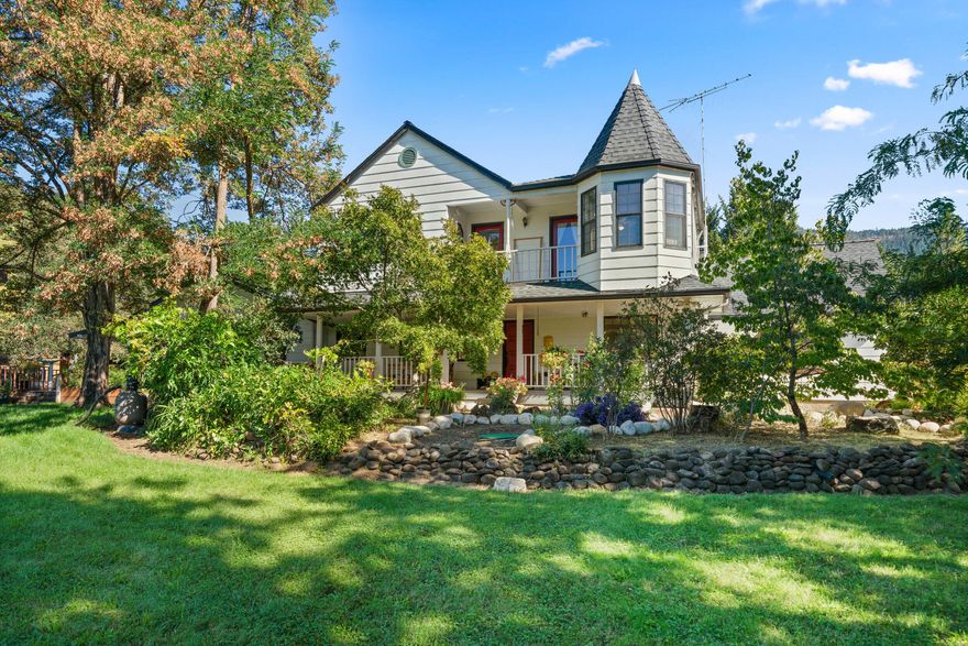 Tucked away on a private road, this 16+acre retreat blends comfort, privacy, and self-sustainability. The 3,572 sq. ft. home offers 5 bedrooms, 3.5 baths, an office, and multiple living areas—including a spacious one-level wing perfect for guests or extended family. Take in sweeping mountain & pastoral views & Sunsets that will take your breathe away!  Enjoy from the wraparound porch, balcony, or while wandering through the irrigated orchard and gardens through Gold Hill Irrigation. Entertain in style around the incredible custom fire pit—this property has even hosted weddings thanks to its breathtaking setting. Extras include a 1,178 sq. ft. shop, 2 car garage,  RV storage, greenhouse, koi pond, and numerous outbuildings. With irrigation rights, space to grow, and a peaceful setting that feels a world away (yet close to town), 15 mins from the airport & easy freeway access.  This property is more than a home—it's a  sustainable lifestyle.