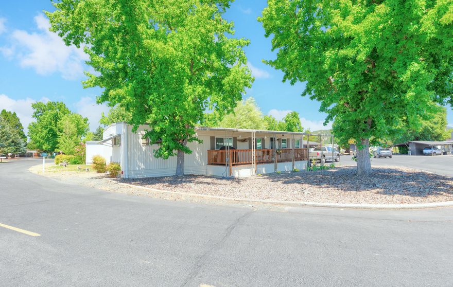 This two bedroom, two bathroom, 1100 SqFt home in Roguelea Estates Mobile Home Park sits on a spacious,private, shady lot with a covered deck to enjoy Summer BBQ's or watch the rain in the Winter time. This home has updated windows, updated beautiful laminate flooring, energy efficient mini split heating and cooling systems and an updated bathroom with an easy-step shower. The kitchen has a gas stove with a custom breakfast nook and formal dining area. You will enjoy the  big windows in the living room that add a ton of natural light to the home.   The primary bedroom has a walk-in closet and private bath. Roguelea Estates is Grants Pass' premier 55+ manufactured home community sitting right along the mighty Rogue River. Living in this community you will have access to a private park along the river where you can watch the famous jet boat races, enjoy river wildlife, and have picnics with your friends and family. Come check this home and park out today!