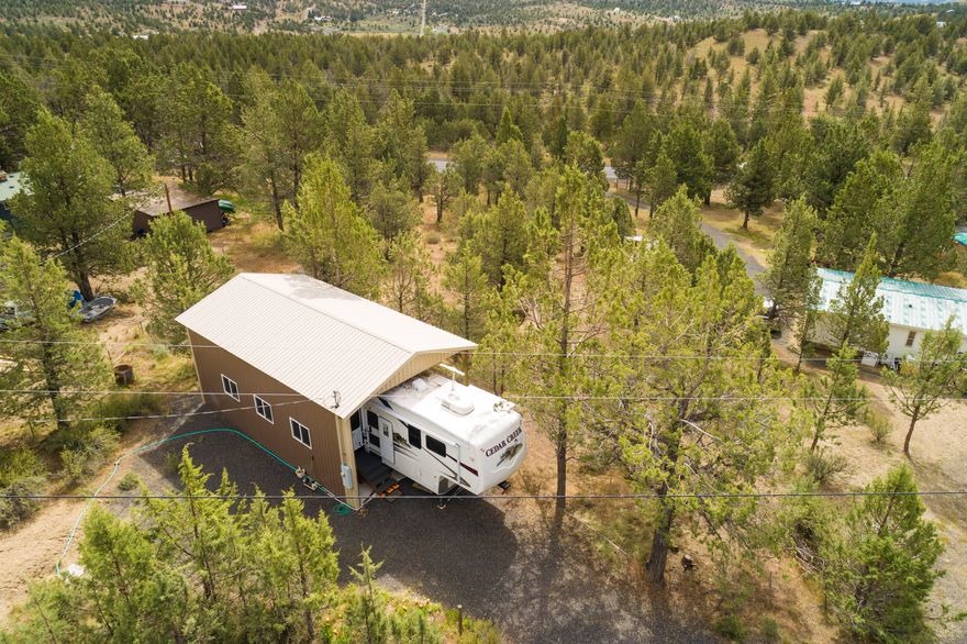 Recreational property with RV cover/pad, septic, water and 200amp power within a couple miles of Prineville Reservoir. Watch the included video for a drone flyover of the property and the adjoining BLM. Just down the paved road to the west is public access to BLM that allows miles of uninterrupted access to trails, recreation, hunting and solitude. The community water is $50 per month and is unmetered. The steel roofed and sided RV cover is a pole construction 36'x20' and is enclosed on two sides.  It could be fully enclosed with a roll up door without much added expense.  It also has a lockable storage area that is fully enclosed as well.  The property is fully fenced and has good juniper cover for privacy.  You can use the lot for a recreational launch pad or as a homesite with all the needed infrastructure already in place!