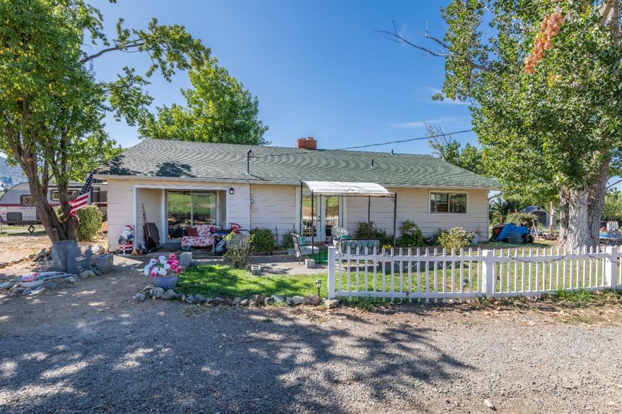 Here is that little rural home tucked away at the end of a long country lane with an Ashland address. This home has very private access. The main home has 3 bedrooms, 1 1/2 baths and had a major remodel in 2012 which included the baths and kitchen. There are laminate floors in the kitchen with newer cabinets. Some great features include a fireplace, paddle fans, vinyl dual pane windows and a large covered patio. There is a separate manufactured home with approved living area for 2 more bedrooms, bath and utility area. Additional storage can be found in 4 storage buildings with cement floors. When friends come to visit there is an RV hookup with plenty or parking area. The fruit trees include 5 plum, 2 peach, 1 cherry, 3 apple, English walnut and grapes. To round out this mini-farm is a chicken house (chicken included if you like) raised garden beds and a small green house. This unique property could be just what you are looking for, see it today.