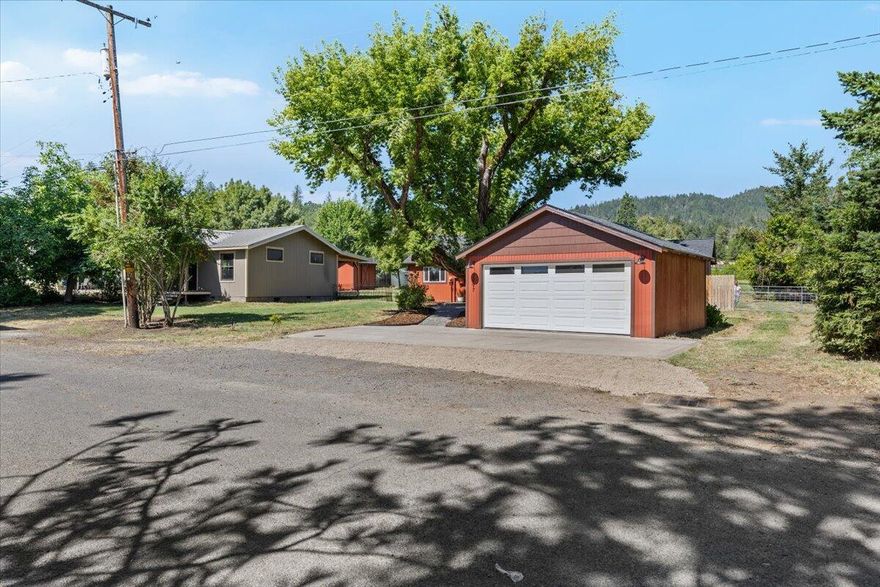 Rustic charm meets modern living, your turnkey homestead just minutes from downtown Central Point. Step inside to vaulted ceilings, reclaimed beams, and a beautifully remodeled interior. A brand-new kitchen, fully remodeled bathrooms, heated primary tile, lighting, and new paint set the stage, while the spacious primary suite features its own coffee bar and kitchenette—perfect for cozy mornings or extended guest stays. Major upgrades ensure this home is as practical as it is stylish. Set on 1.25 irrigated acres, the property is ideal for small farming, gardening, or simply enjoying the space to roam. A charming old barn, decks off the primary and main hall add character and functionality, and a large storage structure with covered back porch is already plumbed and wired for an ADU offers serious potential—just awaiting interior finishes to become a guest house, rental, or creative studio.