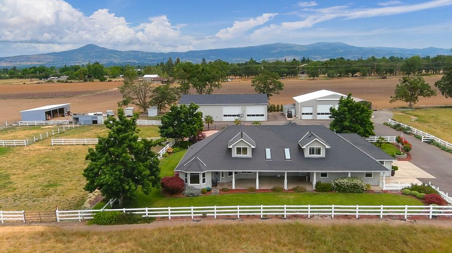 Custom built home on lush grounds, plus ADU guest house, plus studio apartment, huge commercial shops, irrigated pasture, in ground pool on over 5 acres of terrific country setting. Main residence custom built in 2002, 3b/3b home w/modern amenities, in-ground pool, attached 3 car garage, fenced/cross fenced/landscaped on 5.57ac. Includes 2 industrial shops, plus 2575sq. ft. studio, plus 855sq. ft. 2b/1b, ADU residence/many more outbuildings/barns/corrals. Might make wonderful horse property. Irrigated MID. Main well is approx. 8gpm per appraisal. Recent appraisal on file and priced accordingly. Neighboring tax lot and additional home located at 1294 Coghill Ln is also available under listing #220122591 for a total package of over 10ac. with multiple homes/structures potential income.