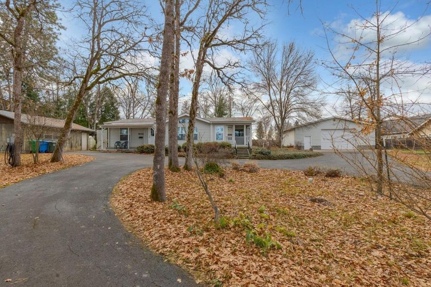 Need a shop? This one acre parcel in Eagle Point, across from the EP Golf Course may be your dream home. The home is a well-cared for 3 bedroom 2 bath 2,400 sq. ft. triple wide manufactured home with island kitchen, living and family rooms. Master bedroom has 2 walk-in closets, dbl. vanity and a jetted soaking tub. The kitchen boasts a walk-in pantry, tile accents, recessed lighting and all major appliances. Outside is a fully insulated and heated 36X40 shop building with 12' ceiling, 10' high, 16' wide garage door, fully plumbed air compressor, paint booth with exhaust, half bath and four 220 amp outlets. The other out building is an older 1 car garage/shop with full RV hookups on the side. The beautiful 1 acre is covered with oak trees for wonderful summer shade. Interior of home was painted Nov. 2019. The land is served by Eagle Point Irrigation District. There are several raised garden beds. This is a very rare property with lots of room for the hobbyist.