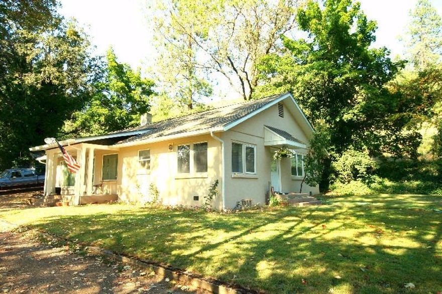 Surprising Mini Farm! Cute 2 bedroom, 1 bath, 1600 sq.ft. 1940's home on above the road placement. Open living area, kitchen with large pantry and lots of natural light and a bright and sunny bonus room works great for office or extra bedroom. Nice size bathroom and a clever built-in desk space in the first bedroom. Updated vinyl windows, spacious rooms and efficient pellet stove insert. The original wood floors would be easy to bring back from under the current carpet. Beautiful rolling 4.9 acres with cross-fenced, pastures and irrigation from the water filled ditch running through the property. Barn with storage, stall and character. Good size animal shed on other end of pasture is nicely suited for medium size animals. Large detached garage with room for 2 cars and storage plus a good size storage building. Ample parking spaces and located in the heart of the Applegate Valley.