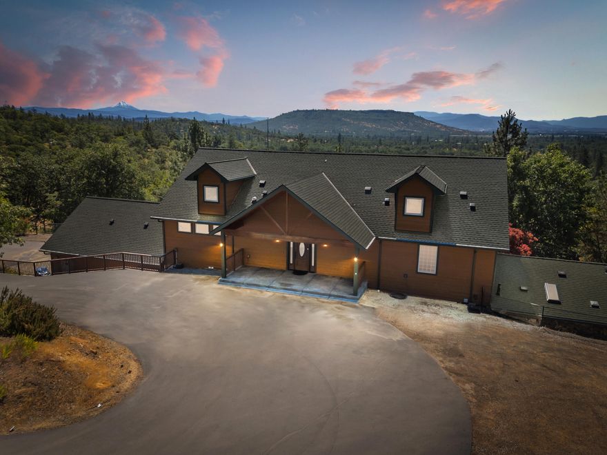 Step into this stunning 3,980 sq. ft. home nestled on nearly 8 acres of serene wooded privacy and two tax lots. Designed for both relaxation and entertaining, this incredible property boasts an indoor pool and spa, offering year-round enjoyment. The main level showcases the primary bedroom, the well-appointed kitchen and breathtaking panoramic views of the iconic Table Rocks and majestic Mount McLoughlin.  
Downstairs, you'll find more bedrooms, a dedicated office, a large bonus area and a stylish wet bar, perfect for hosting or unwinding in comfort. Storage is abundant throughout the home, ensuring ample space for all your needs. 
The oversized 2-car garage offers ample space for parking.
Additionally, there's even some extra space upstairs that isn't included in the official square footage.
Adding to its appeal, this property includes the adjacent bare lot at 947 Rock Way. 
This property offers so many extras including a gated entry, a whole house generator and so much more.