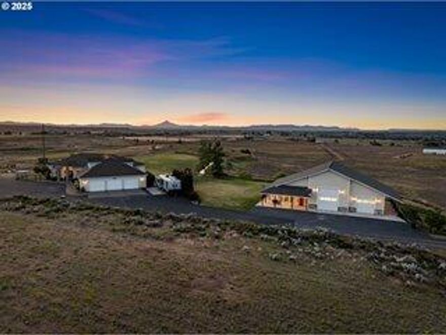 Experience the ultimate Central Oregon hilltop retreat with sweeping views of Mt. Hood, Mt. Jefferson, and the valley beyond! This private estate offers luxury, versatility, and income potential in a serene setting. The main home features 4 bedrooms, an office, and a primary suite with fireplace, spa bath, and deck access. Enjoy the open concept great room and chef's granite kitchen or unwind in the hot tub at sunset. Upstairs, a spacious room serves as a media lounge or bonus suite with panoramic views. A 3-car garage, sauna, and expansive deck add to the luxury. The detached ADU shines with a wraparound porch, hot tub, modern finishes, and quartz countertops, offering flexible space for guests, rental, or multigenerational living (ADU pending Jefferson County approval; buyer due diligence). An RV garage and shop provide storage, hobby space, and include a pickleball court. Minutes from Lake Billy Chinook & Smith Rock, this estate blends privacy, lifestyle & investment opportunity.