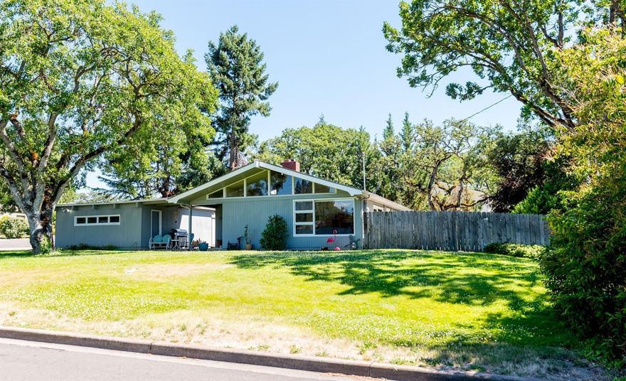 Mid Century family charm awaits. Well maintained 1996 sq/ft home features large brick fireplace, vaulted ceilings and large windows throughout. Home sits on .40 of an acre in desirable Old East Medford. Living & Family room have large glass doors that allow you to view and escape to the amazing outdoor separate spaces surrounding this beautiful home. Master suite is a personal retreat in the back of the home with views of gardens, features large walk-in closet, copeous amount of storage and bath w/double vanities and walk-in shower. Laundry also features built-in storage, w/door leading outside. The huge back yard and patio provides plenty of shade by the mature landscape and trees to enjoy warm evening breeze and has Large RV parking. Come view this amazing HOME. It truly is a must tour.