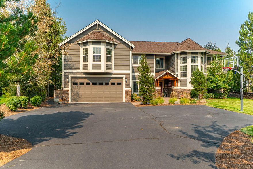 Situated on almost a half acre level lot in distinctive Rivers Edge, this welcoming home offers endless possibilities. The main entry leads into an open living room with a 2 story wall of windows that fill the room with natural light. The two primary bedroom suites, one located on the main floor, give possibilities for main level living or multi-generational living. There is plenty of space for everyone with a great room, bonus room & game room. The primary bedroom suite upstairs is like a private retreat, with a spacious bathroom including dual vanities, a walk-in tile shower with 3 shower heads & soaking tub, its own reading room with a private deck, hidden among the tall pines that line the large lot. The well appointed kitchen is loaded with cabinet & counter space plus a walk in pantry. A 4 car tandem garage allows for loads of room for vehicles, personal gym and storage. And if that isn't enough room there is a new storage closet added to the home, perfect for bikes & skis.