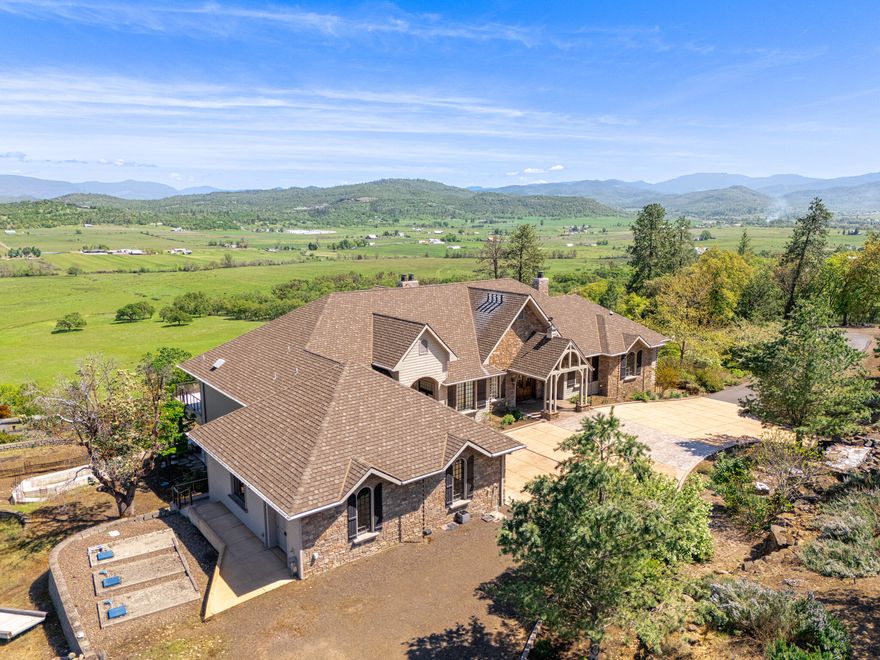 Experience unparalleled luxury in this extraordinary estate set on 20 private acres. Boasting over 10,000 sqft. of refined living space, every inch of this home is designed to impress. The expansive floor plan features a grand primary suite, multiple guest suites, and a spectacular kitchen complete with a massive butler's pantry—ideal for entertaining at scale. Enjoy resort-style living with sweeping views of the valley and Mt. McLoughlin. Built with high-performance ICF construction and certified by Earth Advantage for superior energy efficiency, the home offers exceptional durability and comfort. Geothermal HVAC and in-floor zonal heating provide sustainable climate control. Smart home automation powered by Control4, a new whole-house backup generator, and state-of-the-art systems round out this future-ready estate. This is a rare opportunity to own one of Southern Oregon's most iconic and innovative luxury homes—designed for those who demand excellence and privacy in equal measure.