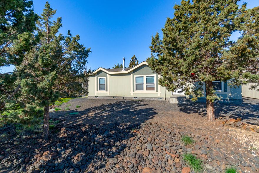 Find your serenity here! Situated on 2+ acres, this property offers a great home & room for hobbies or gardening. Views to the NE as far as the eye can see. Vaulted floor plan is open & spacious w/Master Ste separation. Kitchen features a huge corner pantry, glass cook top range & lots of cabinet space. Adjacent mud room Master bath features double sinks & a tub/shower combo. Walk in closet & linen storage. Two additional bedrooms & full bath at opposite end. Electric forced air heat w/heat pump, wood burning fireplace in the Great Room. Outside you'll find chain link fenced pet & garden areas, raised garden beds, meditation decks & several storage buildings w/power to them. Next to the house is a 2 car garage (just add door) & additional car port for more covered storage or toys. Connected to a shared well & in established neighborhood. Call for private showing!