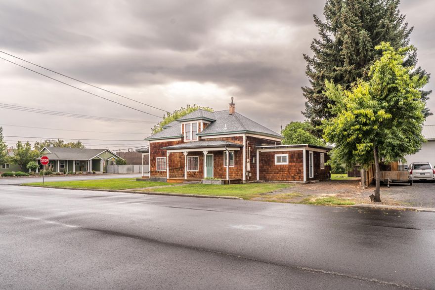 Step into timeless charm with this beautifully maintained Colonial-style home in the heart of Prineville. Rich in character, it features original hardwood floors, a cozy fireplace, and tasteful updates including stainless steel appliances, tile kitchen and bathroom, and a classic clawfoot tub. A sliding barn door adds rustic elegance, while the spacious upstairs bonus room offers flexibility for a bedroom, office, or additional living space. Recent upgrades include new exterior stain and trim paint, some new windows, fresh interior paint, new carpet in the downstairs bedroom, a new toilet, and updated heating. Additional highlights include a laundry room, pantry, RV parking, irrigation well for outdoor watering, alley access, and two well-kept outbuildings—one being a historic carriage shed. Zoned R2, the property allows for an ADU, adding potential for multi-generational living or rental income. New roof in 2022. Classic charm meets modern convenience—come make it yours!