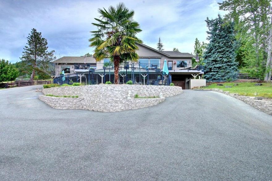 This stunning gated property and home, located in the Applegate Valley, offers everything you need to enjoy the Oregon dream comfortably. The views are breathtaking. As you step out from the great room onto the expansive deck, you can see for miles. Below, you'll find a built-in saltwater pool, a large pond, horse pastures, and magnificent trees and mountains in the background. It's quiet and peaceful, making this home an ideal place to entertain guests and family. The upstairs area features a level entry into the foyer, three bedrooms, and three full baths, along with a sauna. The expansive kitchen is a chef's dream, complete with a double refrigerator, gas range, large granite countertops, and plenty of cupboard space. The downstairs one-bedroom apartment is roomy and comfortable, equipped with its own laundry facilities. You can walk right out to the pool and enjoy a cup of coffee or a glass of wine. So many excellent amenities. Too many to list. Come see for yourself.