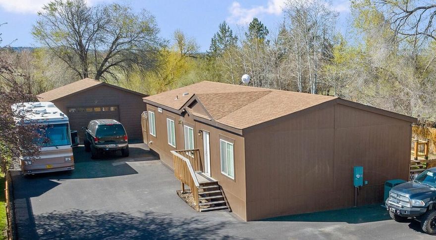 Quiet Neighborhood just outside of Redmond. Large lot with plenty of room in the house and bonus, 24 x 40 shop! Open Kitchen with island convenient for entertaining or functionality. Living Room and bonus space for an Office or Great Room. Home has primary bedroom separated from other bedrooms. Primary also has two large open closets. Skirting on this 2022 Fleetwood is lap siding with R21 insulation, mechanically vented with tie downs, sitting on a slab, exterior painted in 2023.  Live in comfort outside with a large cedar deck, sprinkler system and perimeter fenced. Large Shop is insulated and heated with a concrete floor. Need more storage, there is also a 8X12 shed. RV parking with electrical hook-up. All parking areas are Asphalted and ready to be utilized. Property is supported with AdvanTex septic system. Audio and Video camera's onsite. Call your favorite real estate agent to schedule a showing.