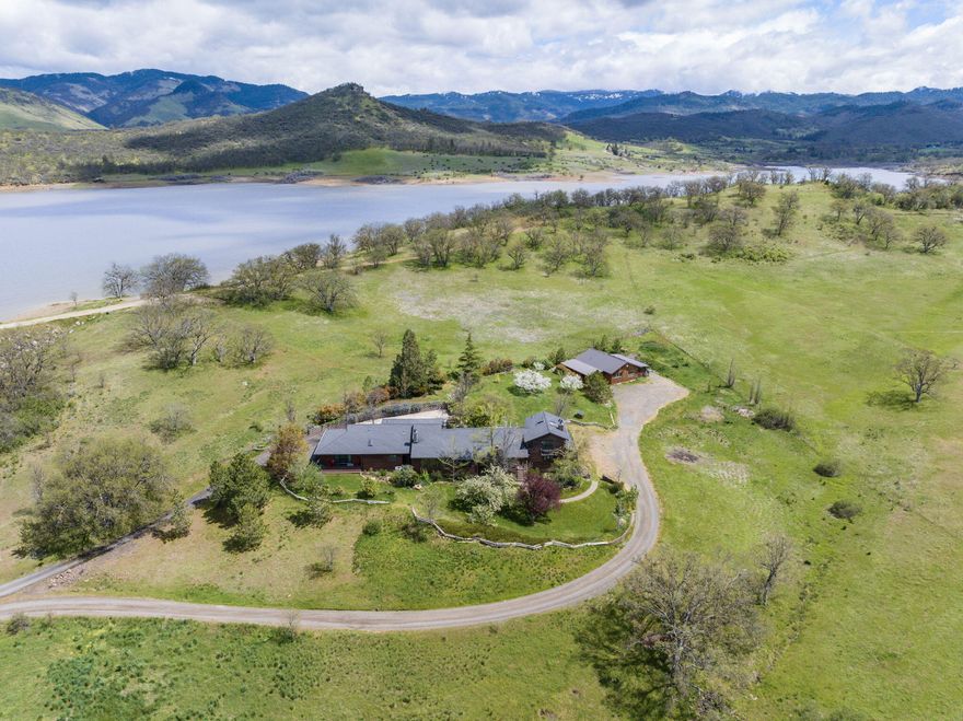 Welcome home to your tranquil Emigrant Lake retreat in beautiful Ashland, Oregon. Situated on 5 fertile & gently sloping acres, this unique property backs up to public lands bordering the lake, offering private access to the wide open space & cool water below. Built in 1981 and lovingly maintained & updated by the original owner, this 3726SF home is spacious without being ostentatious, and could easily accommodate a two-family setup. The main level offers 2 large owner suites, a living room w/ vaulted ceilings & fireplace, 2 laundry rooms, 1.5 bathrooms, and a graciously remodeled kitchen with breakfast bar & addt'l eating area. The opposite wing of the house has a separate sunken living room with cozy wood stove, 2 bedrooms, office & sunroom. Upstairs is one last en suite w/ private balcony, fireplace, and sauna. An 800SF 'barndominium' renovated in 2015 functions as a guest apartment. From green pastures to peaceful sunsets, this property must be seen to be appreciated.