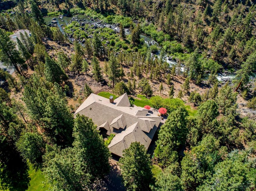 This is a rare, private, and awesome property: 3.9 acres with spectacular river and mountain views, 5 minutes from both malls, 8 to downtown, and with a 4151 sq. ft. immaculate contemporary home. This property extends to the middle of the river. The grounds are manicured with paver driveway & patio, 3 car garage, storage shed, 1 ac. of irrigation, and a path to the river for fishing or hiking. Main level living features a large master bedroom and elegant marble bath plus exercise room, and his and hers walk in closets. 2 additional upstairs bedrooms, 2.5 baths total, formal dining area, breakfast nook, family room, and office complete this elegant home. The kitchen has dual built in freezer drawers, dual ovens, and dual sinks as well as a Sub Zero fridge and 6 burner cook top. For gourmet chefs there's abundant counter space and a built in kitchen desk. The home has sound in all rooms. This property is on a shared well for superb water. This home has privacy, proximity, and pizzazz.