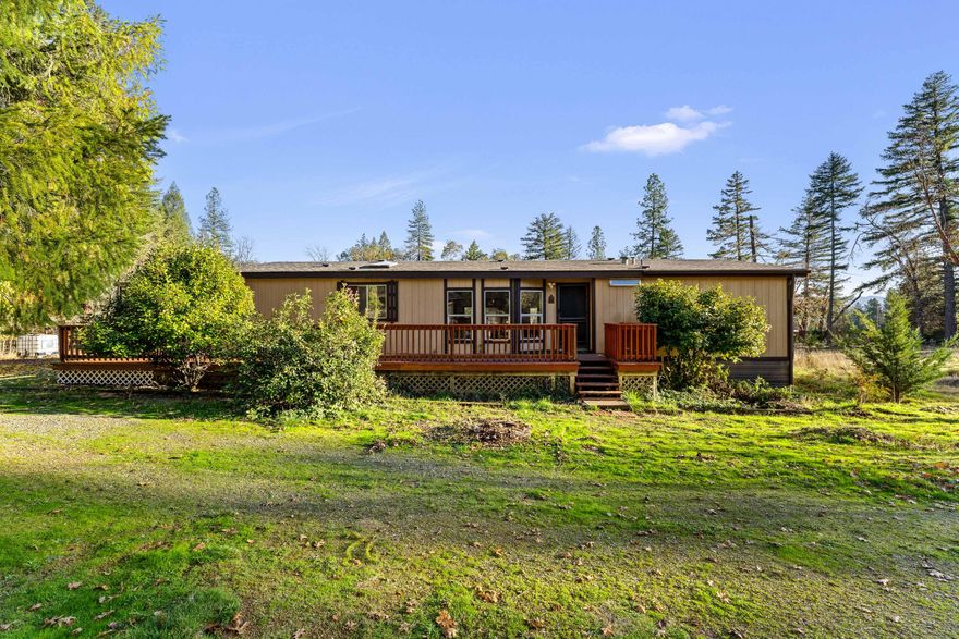 Are you looking for affordable living in the county, but not far from conveniences? Then this is it. This 5.03 acre property is flat and useable with a well kept 1986 double-wide manufactured home, and is located just about 20 miles from the city of Grants Pass. This comfortable double-wide has an open layout with plenty of natural light and offers 3 bedrooms, 2 full bathrooms, and 1512 sq.ft., as well as a new roof. Roof was replaced on 7/27/24. The primary suite has a nice sized walk-in closet. Outside you will find a spacious shop with RV hookups and plenty of storage space. Come enjoy the country lifestyle.