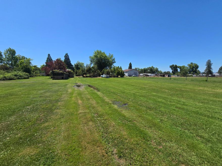 County property is perfect for your horse, cow, chickens or even your goat. Stocked 12x24 fish pond. Medford irrigation ditch provided ample water all Summer. This property is a hidden paradise and a must see. Price reduced for quick sell. Rare .99-acre development property in Medford with a 3/1, 880 sq.ft. fixer home. Prime location near shopping, medical offices, restaurants, schools, and parks, offering excellent accessibility and visibility. Utilities at the curb ensure efficient, cost-effective development. This flat, usable lot is brimming with potential—perfect for multifamily units, investment property, or diverse development options. Seize this incredible opportunity to own a well-located parcel in a thriving area!