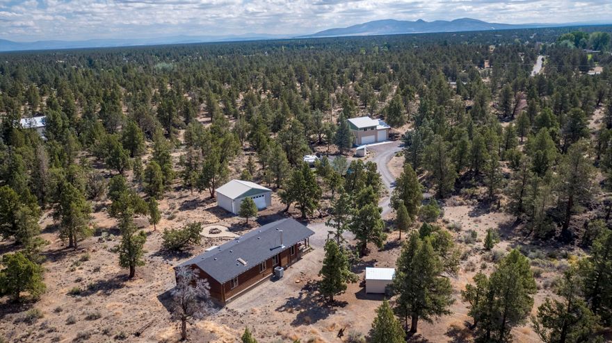 Experience the tranquility of nearly 20 acres on Bend's North end.  The topographical character of this property amplifies its privacy & mountain views. The existing manufactured home is strategically placed for its tranquil setting, views while retaining the option to construct a future home in an ideal area of the lot affording the next owner the ability to live/use the existing home while they build their dream.  The gated, cinder driveway weaves between old lava flows to reveal a 1368sf heated workshop (200a service w/220v), dual bay doors (8x18 door & 12x12 door), 864sf second floor storage/possible studio & an adjacent RV parking pad.  The residence is further up the drive perched atop a knoll and features an upgraded HVAC system, upgraded energy-star windows and meticulously cared for.  Adjacent to the home is a detached two car garage that can readily be relocated to allow for more improvements in the future.  The property was professionally cleared to improve defensible space