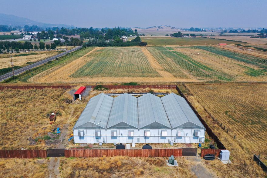 Chunky Knob Farms is a premium facility located just on the outskirts of Medford in the famous Emerald Triangle. This farm sits on 4.38 MID irrigated acres of Exclusive Farm Use land. Included in the sale is a Tier 2 Producers license. Current configuration, 10,080 sqft. of greenhouses (4 sectioned at 2520 ea) with light dep. each greenhouse has four 4'X8' live soil beds separated by 8' aisles and 3 phase, 600 amp, 480 volt panel servicing 3520 sq ft of indoor canopy that is expandable by another 320 sq ft. The
outdoor space is configured for 20,000 sq ft of canopy in 1 yard air pot containers w/live soil. There is a 1800 sq ft utility building that is climate controlled used for trimming, packaging and product storage. The property is perimeter fenced, OLCC compliant security system, irrigation reservoir. Current production methods are yielding between 700-950lbs of trimmed product annually and the farm has
relations with many retail outlets. Ask for a detailed package on this farm