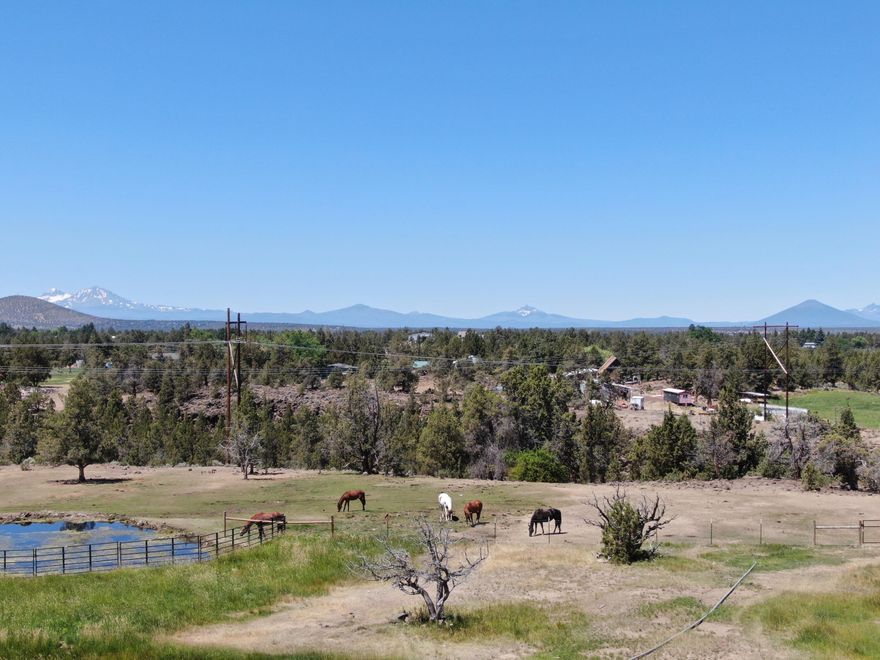 Cascade Mountain views! This meticulously maintained single level property is complete with mature landscaping framing the Cascade Mountain views from the main home, fenced and cross-fenced with 2 outdoor arenas, barn, 10.5 Acres of COID irrigation, shop, and bunk house! The property is gated and set up for both cattle and horses!