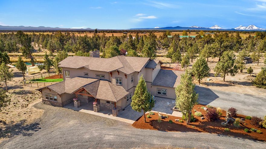A true diamond in the country. This 23-acre spread is dotted with junipers, pastureland, and borders the canal on its west end.  The 4000 square foot custom home has a massive, vaulted ceiling with exposed wood beams, a blended hickory and concrete floor, a beautiful kitchen with slab granite counters and a six-burner range. The main level bonus room harkens back to the Old West with saloon doors and horseshoes in the floor. Upstairs, the oversized master bedroom has its own fireplace, a deck with Cascade Mountain views, a spacious bathroom with soaking tub, and a large walk-in closet. Outside, the backyard is beautifully landscaped and fenced. Beyond the fence, there is a large irrigation pond with an island and a zipline. The shop has been updated to accommodate a large RV and also has plenty of storage space. The property has 4 acres of irrigation with an automated sprinkler system and a fenced pasture. This property is the perfect blend of privacy and class.