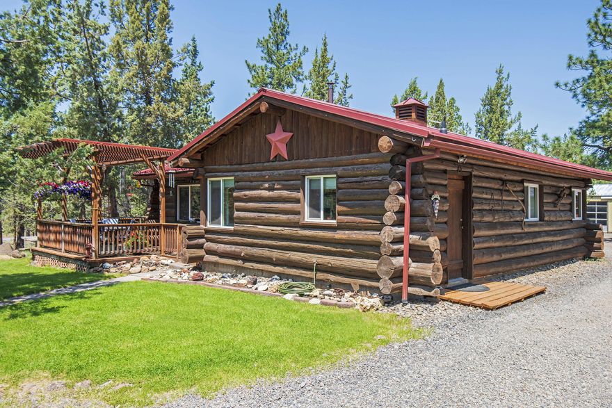 Rustic & Charming single level log home on in the in a cul-de-sac on 5.09 acres. Great location just down the road from Aspen Lakes Golf course. Hand hewn logs, metal roof, large front deck with an inviting arbor. Kitchen features blue & buggy knotty pine cabinets, eating area with corner windows. Hawaiian King Koa laminate wood flooring, open floor plan, good number of windows, built in desk and wood pellet stove. Out buildings include a ''Log garage'': 29' x 29' w/8'x10' single wide roll up door, heated, 220 electric, pull down storage, covered front paver patio. Pole barn/shop: 48'x 24' w/ 10'x10' roll up door & 11'x 10' sliding door & 220 electric. Carport: 15'x18' carport. Woodshed: 16'x 22' with 2 covered storage areas. Covered RV pad: 18'x30', 30 amp electric and 14'x10' deck. New septic tank in 2022. Single party well with a new pump & casing in 2020. Circular driveway, old growth trees and lots of room for your vehicles, RV(s), boats, trailers, trucks, toys and more.