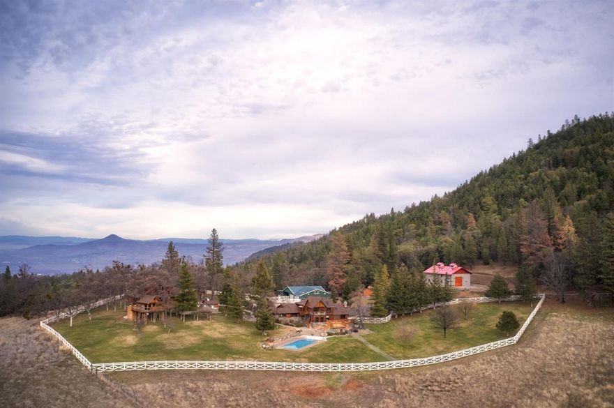 The Rusty Spur Ranch, a valley of its own above the fog. This secluded property has end of road privacy and is a short distance to Ashland or Medford. Covering 319+/-acres this estate quality property is located in a highly sought area of the Rogue Valley. Two homes, two shops, horse stable, covered riding arena and other outbuildings accent the property that offers views of the surrounding area and valley below. Three back-up generators add to peace of mind and self sufficiency. The 2150 square foot 2 bed, 2 bath expansive log home, constructed in 2013, features soaring ceilings and high end appliances. The 3585 square foot 3 bed 3 bath main home offers views of the expansive pasture and tree lined mountains in the distance.Meticulous landscaping surrounds the homes and includes a swimming pool, water features and a nicely appointed tree house. The horse barn has 12 stalls (7 with turnouts) and the arena is approx. 80X225. The workshop is climate controlled and has all of the extras.