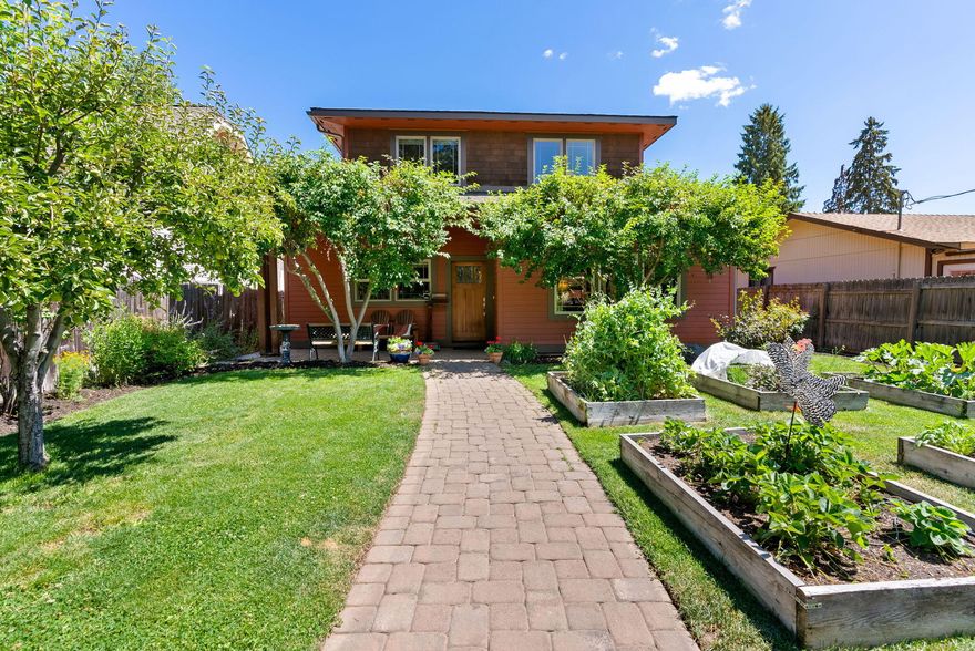 Located in Bend's sought-after River West neighborhood, this custom prairie-style home offers 1,950 sqft of quality craftsmanship, vaulted ceiling, and well-designed open floor plan. The two-story layout includes 3 bedrooms, 3 full baths, spacious great room concept, large kitchen, dining space, and an upstairs bonus-space. The oversized, alley-access garage provides ample storage, workspace, and/or additional parking. Enjoy outdoor living with two balconies, front/side patios, established garden beds, berry bushes, and mature fruit trees—all within a large, fully fenced yard. Set back from the street for added privacy, yet just blocks from Drake Park, Downtown Bend, Newport Market, local eateries, and cafes. Nearby, you'll find the Old Mill District, river access, Bend's whitewater park, walk/bike trails, music venues, local breweries, and more—plus convenient access to Mt. Bachelor, Phil's Trail, multiple lakes, golf courses, and many other outdoor adventures. Westside Bend living!